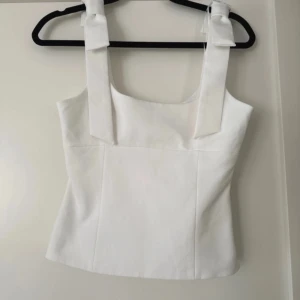 Vitt linne med rosetter - Super sött linne från zara med rosetter på axlarna i storlek xs. 