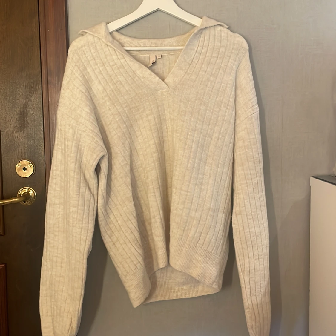 Beige ribbstickad hoodie med v-ringning