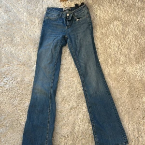 Blå bootcut jeans från Zara - Snygga blå jeans från Zara med klassisk bootcut-modell. Jeansen har normal midja, fem fickor och stängs med knapp och dragkedja. Perfekta för dig som gillar en tidlös och avslappnad stil. Säljs inte på hemsidan 