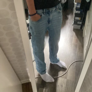 Ljusblåa loose fit jeans - Säljer ett par ljusblå jeans med loose fit och raka ben. Klassisk femficksmodell med normal midja och avslappnad passform. Perfekta för en chill och avslappnad stil. Materialet är klassisk denim i bomull.