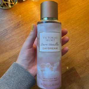 Victoria's Secret Bare Vanilla Daydream - Fräsch och söt body mist från Victoria's Secret i doften Bare Vanilla Daydream. Flaskan är 250 ml, har en mjuk pastellrosa och vit design med guldiga detaljer och ett matt guldigt lock. Perfekt för dig som älskar vanilj och vill ha en lätt, drömmig doft. Använd ca 5 gånger så mycket kvar i. Köptes för 220kr! PRIS KAN DIKSUTERAS