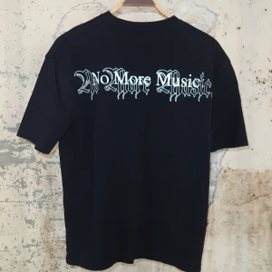Svart t-shirt med tryck FENTY - Från Rihannas klädmärke FENTY. Cool svart t-shirt med stort färgstarkt drakmotiv i blått och gult på framsidan och texten 'No More Music' i gotisk stil på ryggen. T-shirten har klassisk passform och korta ärmar. Perfekt för dig som gillar streetwear och unika prints.