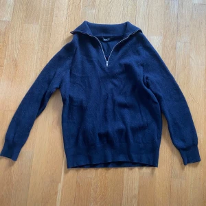 Mörkblå half zip-tröja Massimo Dutti - Mörkblå stickad tröja från Massimo Dutti med half zip-dragkedja och hög krage. Tröjan har lång ärm och ribbade muddar vid ärmslut och nederkant. Perfekt för lager-på-lager och chill höst- eller vinterstil.