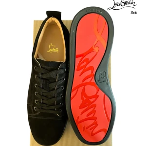 Christian Louboutin svarta sneakers - Svarta sneakers från Christian Louboutin i mocka och skinn med klassisk röd sula och diskret logga. Snygg snörning och rund tå ger en clean look. Perfekta för dig som vill sticka ut med exklusiva detaljer och lyxig känsla.