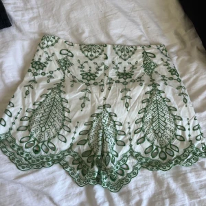 Populära vita Zara shorts med grön brodyr - Vita shorts med grön broderad design och vågig kant. Jättesnygga men kommer ej till användning, aldrig använda💕 eftertraktade från Zara!