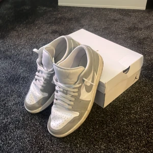 Nike Air Jordan 1 Low - wolf grey  - Jag säljer ett par riktigt snygga Jordans som säljs i nyskick för 2200kr. Skorna är i ett hyfsat skick men är lite creasade. Säljs också med skolådan. Priset går att diskuteras. Det är bara att höra av sig!