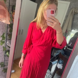 Röd omlottklänning från Lindex - Snygg röd långklänning från Lindex med omlottmodell och knyt i midjan
