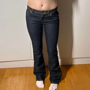 Lågmidjade bootcut jeans mörkblåa med guld sömmar - Mörkblåa med guldiga sömmar. Från Roberto cavalli x h&m. Står ingen storlek men passar ungefär en w27. Se mått. Innerbenslängd: 85 midjemått:38 köp sker via köp nu, jag postar inom 24h. Kvar tills markerad såld