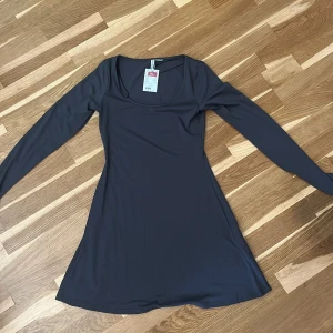 Långärmad klänning H&M - Klänning från H&M med lång ärm och rundad urringning. Modellen är kort. ALDRIG ANVÄND 