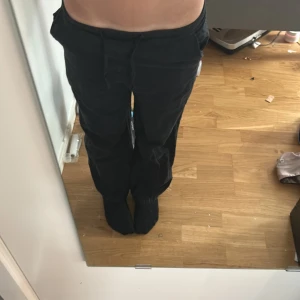 Svarta linnebyxor med snörning - Svarta linnebyxor  med avslappnad passform och snörning i midjan. Perfekta för chill dagar eller när du vill vara bekväm. Byxorna har raka ben och är gjorda i mjukt material.