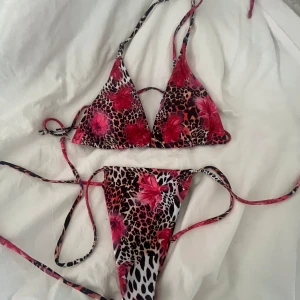 Leopardmönstrad bikini med blommor - Triangelbikini med leopardmönster och stora rosa blommor. Snygga knytband både upptill och nedtill för en justerbar passform. Färgerna går i svart, beige, vitt och stark rosa. Perfekt för stranden eller poolen om du vill sticka ut. Den är i storlek M💕Jag köpte den utomlands för 200kr. Inte använd bara testad💕pris går att diskutera om…