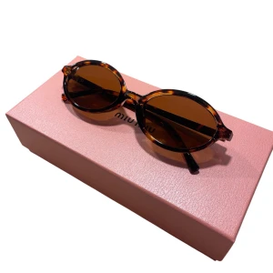 Bruna ovala solglasögon  - Snygga solglasögon med oval form och brunmelerat sköldpaddsmönster. Glasen är bruna och bågarna har en cool retrovibe. Perfekta för att lyfta vilken outfit som helst och ge en trendig touch.