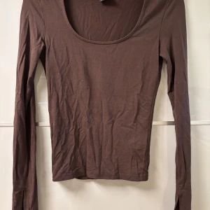 Brun långärmad topp med slits från GinaTricot - Säljer denna bruna långärmad topp med från gina tricot. Den är använd endast en gång, men insåg då snabbt att den var för liten för mig. Storlek XXS