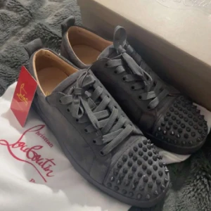 Christian Louboutin grå sneakers med taggar - Grymma grå sneakers från Christian Louboutin i mocka med coola taggar