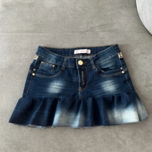 Lågmidjad kjol med volanger  - Säljer en lågmidjad jeanskjol med volanger som jag sytt själv väldigt noga 🤎 Super fint leopard mönster och cool detalj på bakfickan. Midjemått 36 cm, längd fram 27 cm, längd bak 32 cm .