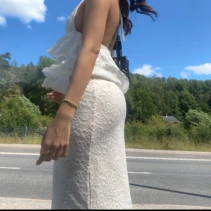 Lågmidjad spetskjol - Säljer en otroligt somrig vit spetskjol endast använd en gång vid midsommar!☀️🫧 kjolen slutar precis innan fötterna och har en slits som börjar vid knäet på ena sidan!🤩