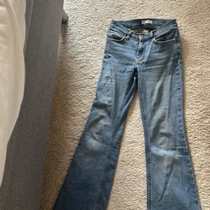 Bootcut jeans från Perfect Jeans - Snygga ljusblå bootcut jeans från Perfect Jeans med klassisk femficksdesign och orangea kontrastsömmar. Jeansen har normal passform och är tillverkade i mjukt denimtyg som ger en skön känsla. Perfekta för dig som gillar retrovibbar och vill ha ett par jeans med utsvängda ben.