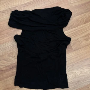 Svart one shoulder topp - Snygg svart topp som är off shoulder. Perfekt för lite festligare tillfällen 💓, den har aldrig kommit till användning .