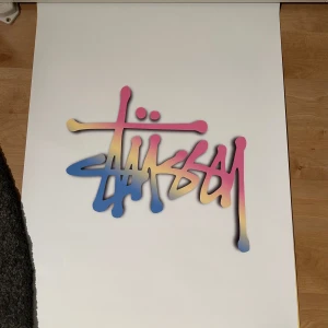 Stussy affisch  - Stil ren vit Stüssy-affisch med den ikoniska loggan – ett måste för alla som gillar streetwear och modern inredning. Perfekt som väggdekoration i sovrummet, vardagsrummet eller i ett kreativt utrymme. Enkel, trendig och full av attityd. Redo att ramas in eller hängas upp som den är!
