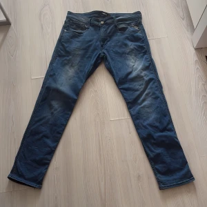 Blå Replay jeans anbass 33/30 - Snygga blå jeans från Replay med klassisk femficksdesign och raka ben. Jeansen har en tydlig Replay-patch bak i midjan.  Tillverkade i mjukt jeanstyg som sitter skönt hela dagen. 