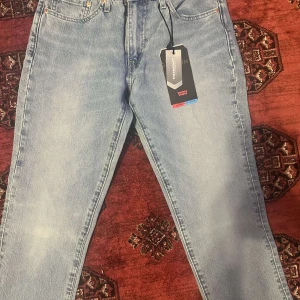 Levi's 514 ljusblå jeans med Thermadapt - Ljusblå Levi's 514 jeans med klassisk femficksdesign och Thermadapt-teknologi för extra komfort. Raka ben och normal passform, tillverkade i mjukt denim. Snygga detaljer som läderpatch och röd Levi's-tag på bakfickan. W32 L32