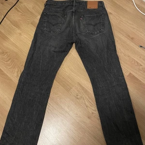 Levi's 501 svarta jeans 34/32 - Klassiska svarta Levi's 501 jeans. Förutom att de är lite nötta längst ner så är dom i riktigt bra skick då de är sparsamt använda.