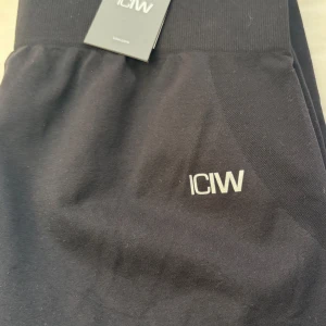 Svarta leggings från ICANIWILL Smooth - Svarta leggings från ICANIWILL med diskret logga på benet. Stretchigt material som sitter tight och passar perfekt till träning. Hög midja för extra komfort och snygg passform.