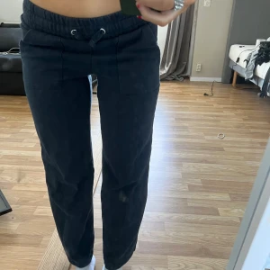 Svarta mjukisbyxor med dragsko - Säljer ett par svarta mjukisbyxor med elastisk midja och dragsko. Byxorna har en avslappnad passform och är perfekta för en bekväm stil. De har fickor på sidorna för extra funktionalitet.