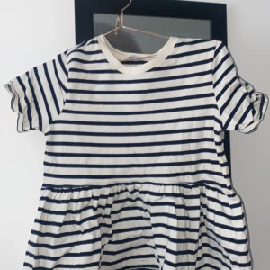 Randig blus från Zara - Säljer en söt randig klänning från Zara i marinblått och vitt. Klänningen har korta ärmar och en avslappnad passform med en lätt rynkad midja. Perfekt för en avslappnad dag ute eller en fika med vänner. Jag vet inte vad nypriset är men jag säljer den för 120 kr. Det är i ett bra skick. Den är i storlek S.  🦋