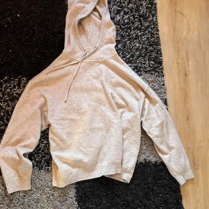 Grå hoodie från Marc O'Polo cashmir  - Säljer en stilren grå hoodie från Marc O'Polo. Den har en klassisk design med dragsko i huvan och ribbade muddar. Perfekt för en avslappnad look. Passar både till jeans och mjukisbyxor. Kashmir cashmir 