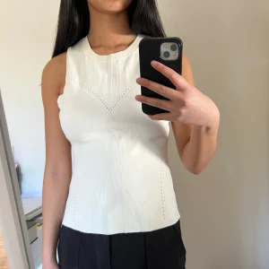 Vitt ribbat linne And Other Stories - Säljer en stilren vit ribbad/finstickad linnetopp med hålmönster. Toppen är ärmlös och har en tight passform. Den är stretchig och lite för stor för mig, så därför ser den lite konstig ut vid armvecken, men den ser säkert bra ut på nån annan. Har en cremevit färg. 