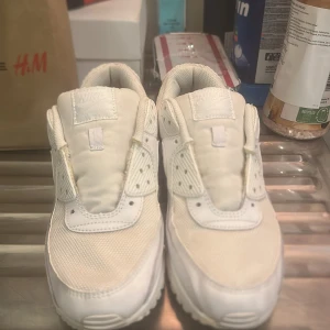 Vita Nike Air Max sneakers - Säljer ett par vita Nike Air Max sneakers. De har en klassisk design med synlig luftdämpning i sulan och en stilren look. Perfekta för både vardag och träning.