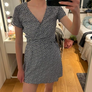 Blåvit blommig klänning & other stories  - Säljer en söt  blommig klänning med v-ringning och korta ärmar. Klänningen har en omlott-design som ger en fin passform. Perfekt för sommarens alla tillfällen! & other stories nypris ca 900. Använd 1 gång