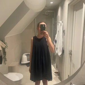 Marinblå klänning med glitterdetalj - Fin klänning utan tecken på användning, lappen är dock bortklippt. Hör av er vid fler bilder. 