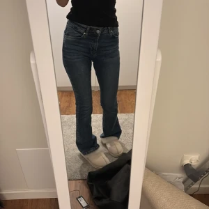 Blå jeans med bootcut - Säljer ett par klassiska mörkblå jeans med bootcut. De har en normal passform och är lågmidjade, dom är väldigt stretchiga och känns inte som de typiska jeans man tänker på som är trånga och obekväma. Dessa är både snygga och sköna. De passar perfekt för mig som är ca 164 i längden. 
