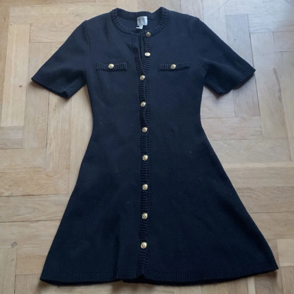 Svart stickad klänning med guldknappar - 1