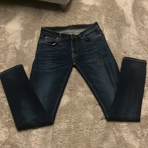 Mörkblåa Nudie jeans - Jag säljer ett par Mörkblåa Nudie jeans. Jag har använt de 1 gång men är för små. De är slim fit och har storleken 29 W och 32 L. Jag har ett pris på 500 kr men det kan diskuteras.