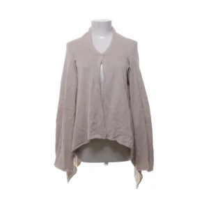 Beige kofta från Hunkydory Essentials - Säljer en stilren beige kofta från Hunkydory Essentials. Koftan är tillverkad i 100% bomull och har en unik design med längre framstycken. Perfekt för lager-på-lager och ger en avslappnad look.