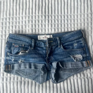 Blå lågmidja jeansshorts från Hollister - Snygga blå jeansshorts från Hollister. Storlek w25 eller XS! Midjemått är 38cm💕