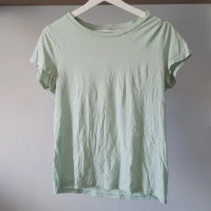 Ljusgrön t-shirt från H&M Divided - Mintgrön / ljusgrön t-shirt från H&M Divided. Den är kortärmad och tillverkad av en mjuk blandning av bomull och viskos. Använt skick därav priset (lite nopprig och visst ljus ser området under ärmarna lite gråare/mörkare ut) 