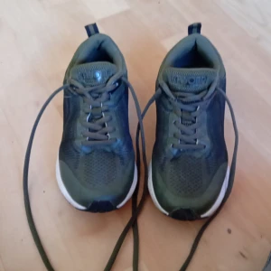 Gröna sneakers från Kayoba - Säljer ett par gröna sneakers från Kayoba med snörning och vit sula. Perfekta för utomhusaktiviteter med en bekväm passform och stilren design.