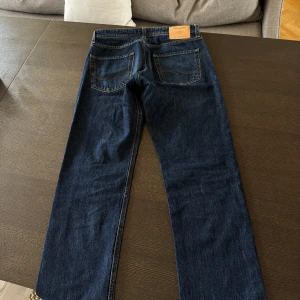 Mörkblå jeans från Jack & Jones - Säljer ett par mörkblå jeans från Jack & Jones.  För dig som vill ha en par mörkblåa och raka jeans som varit använda några enstaka gånger. Inga täcken på slitag eller användning