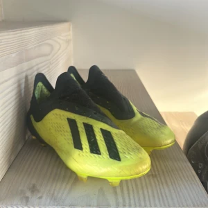 Adidas Fotbollskor - Snygga dojor från Adidas Speedmesh elite modell med svarta detaljer och tre ränder på sidan. Skorna är använda men inga skador eller liknande. Storlek 39 1/3. Skriv vid fundergingar!!