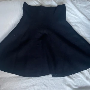 Svart kjol - Snygg svart kjol med en klassisk design. Kjolen har en enkel och elegant stil som passar perfekt för olika tillfällen. Den är gjord i ett mjukt och bekvämt material som ger en fin passform. Kjolen är från bikbok. Går att pruta. Aldrig använd 