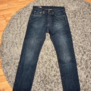 Levi's 501 jeans - Säljer ett par klassiska Levi's 501 jeans i mörkblå denim. De har en rak passform och är tillverkade i slitstarkt jeanstyg. Perfekta för en tidlös stil.