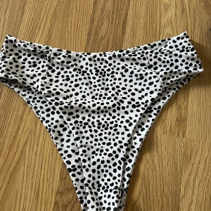 Prickig bikiniunderdel från SHEIN - Snygg bikiniunderdel från SHEIN med ett trendigt svartvitt prickigt mönster. Perfekt för en dag på stranden eller vid poolen. Tillverkad i mjukt och bekvämt material.