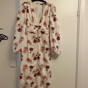 Vit blommig långklänning - Virala vita klänningen från GinaTricot. Slutsåld och säljer helt oanvänd med prislappen kvar. 