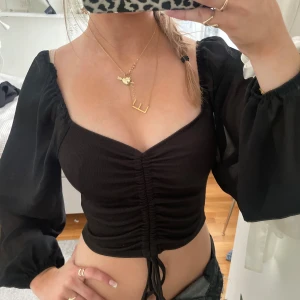 Svart blus  - Snygg svart blus med puffiga, långa ärmar och knytning framtill. 💖