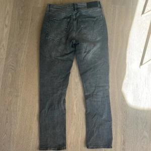 Grå jeans från Stock & Hank - Snygga grå jeans från Stock & Hank med en klassisk femficksdesign. De har en rak passform och är perfekta för en avslappnad stil. Tillverkade i slitstarkt denim med knapp och dragkedja framtill.
