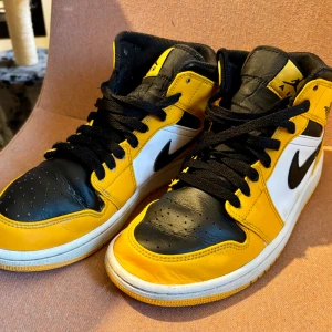 Nike Air Jordans i svart, vitt och gult - Snygga Air Jordan 1 Gul/Svart EUR 40.5.Fin gul och svart färgkombination. Klassisk design med Air Jordan-loggan. Perfekt för både vardagsbruk och speciella tillfällen. Begagnad skick såsom gåveck och lite skav här och där men ny putsade och impregnerade. Funkar bra långt in på hösten! Nypris cirka 2000 kr. Original kartong medföljer.